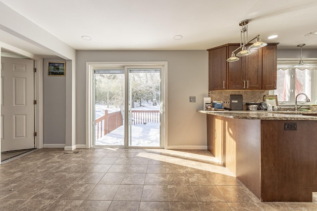 kitchen featuring light tile patterned floors, sink, pendant lighting, and tasteful backsplash