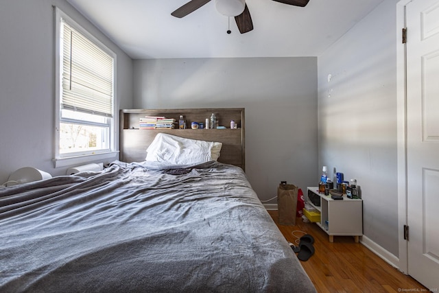 bedroom with ceiling fan and dark hardwood / wood-style flooring