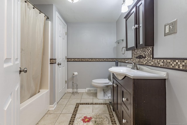 full bathroom featuring tile patterned flooring, toilet, shower / bath combo with shower curtain, vanity, and decorative backsplash