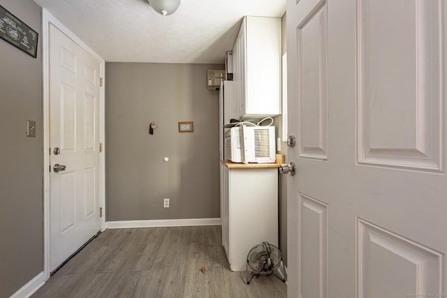 doorway with light hardwood / wood-style flooring and a textured ceiling