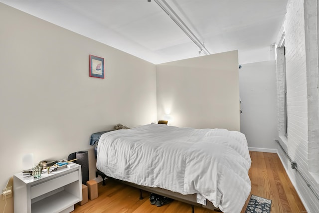 bedroom with baseboards and wood finished floors