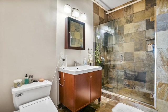 bathroom with vanity, a shower stall, and toilet