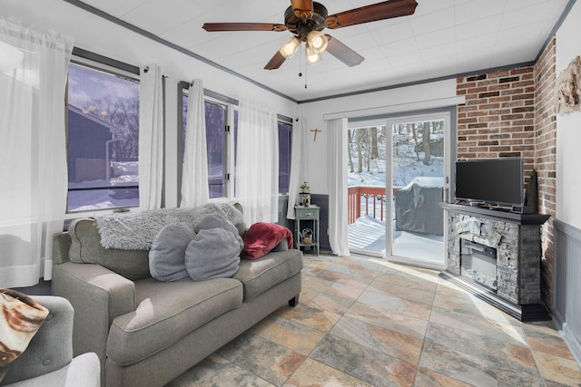 living area with ceiling fan, a fireplace, and stone finish floor