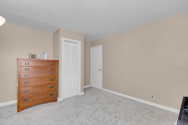 unfurnished bedroom with a closet, carpet, and baseboards