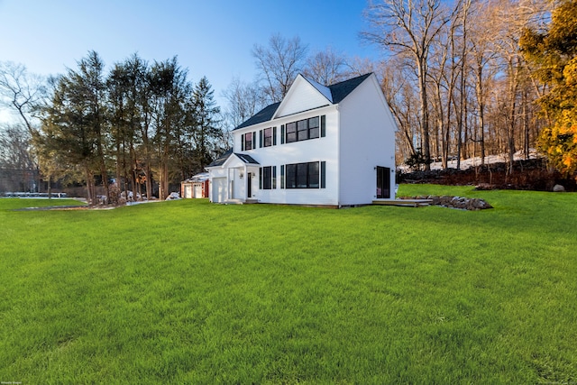 back of property featuring a garage and a yard