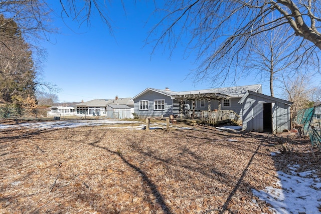 view of front of house featuring a storage shed, a deck, an outdoor structure, and fence