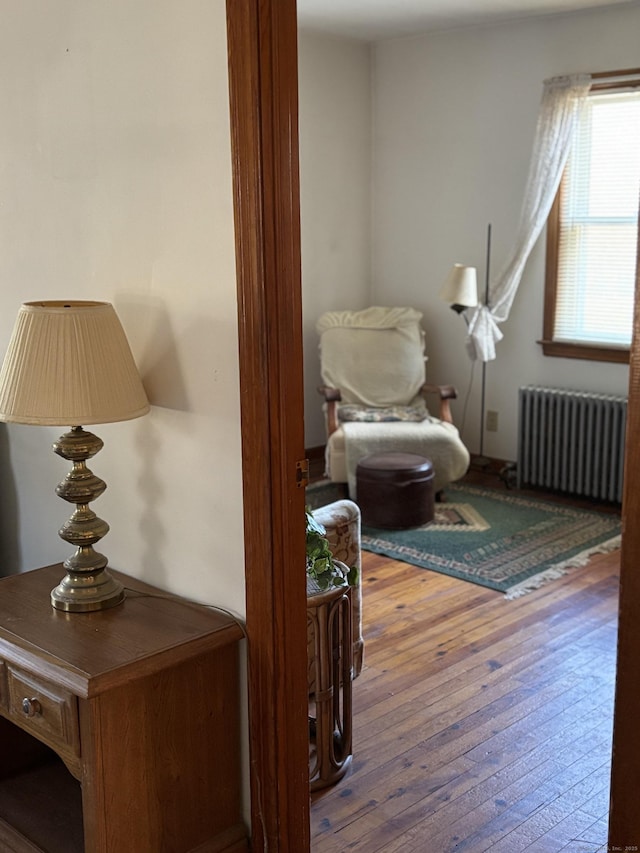 interior space with radiator and hardwood / wood-style flooring