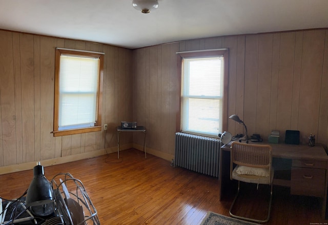 office area featuring radiator, baseboards, and wood finished floors