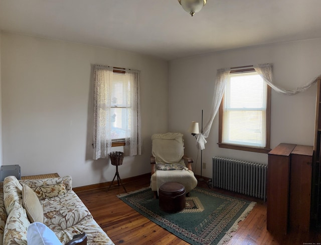 sitting room featuring radiator, baseboards, and hardwood / wood-style flooring