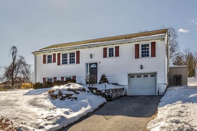 bi-level home featuring aphalt driveway and an attached garage