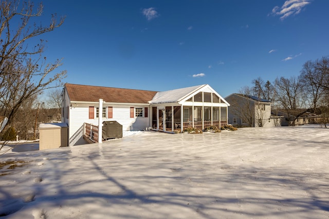 snow covered property featuring a sunroom