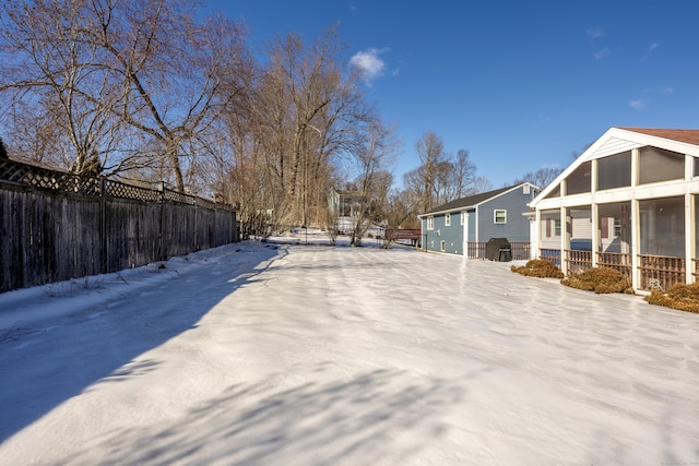 yard layered in snow featuring fence