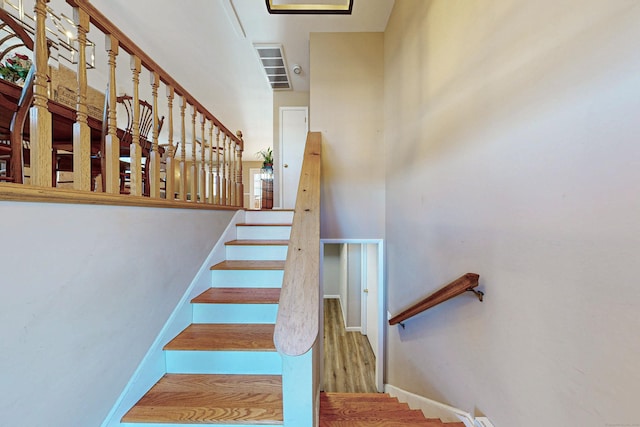 staircase featuring baseboards and wood finished floors