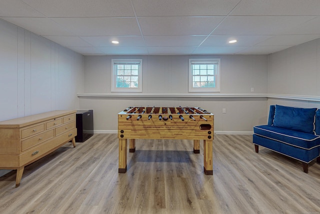 playroom with baseboards, a drop ceiling, plenty of natural light, and light wood-style floors