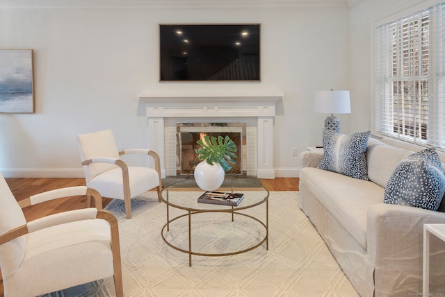 living room featuring light wood-type flooring, a fireplace with flush hearth, and baseboards