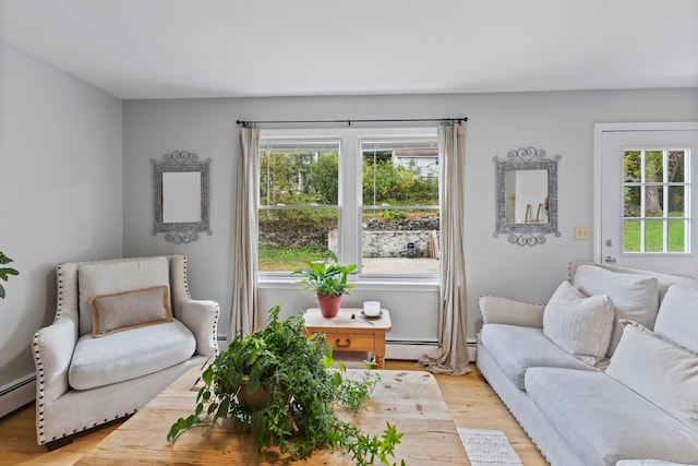 living room with baseboard heating and light hardwood / wood-style flooring