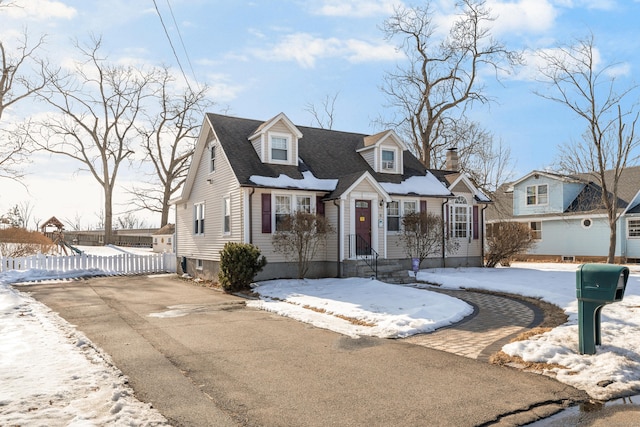 view of front of property featuring driveway, roof with shingles, and fence