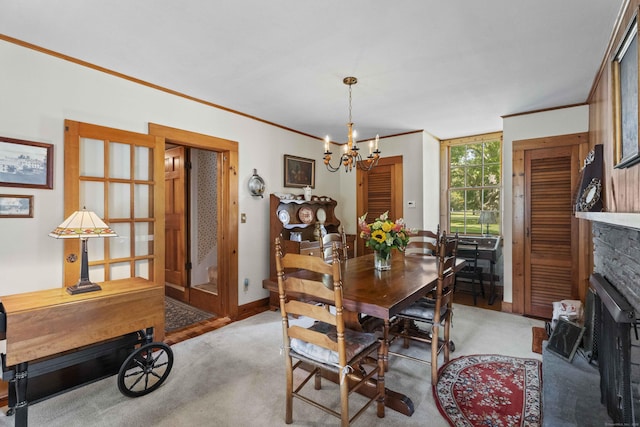 dining room with light carpet, baseboards, crown molding, a fireplace, and a notable chandelier