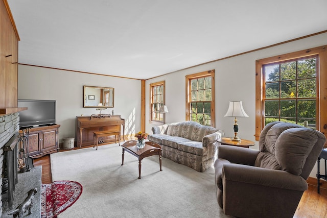 living room featuring a brick fireplace, ornamental molding, and wood finished floors