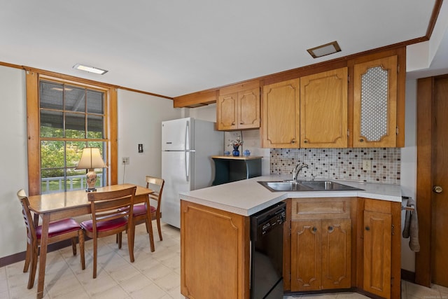 kitchen featuring black dishwasher, light countertops, a sink, and freestanding refrigerator