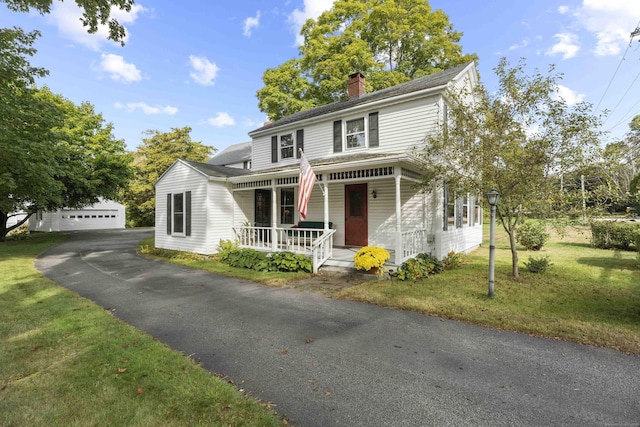 view of front of property featuring a porch, a garage, an outdoor structure, a front lawn, and a chimney