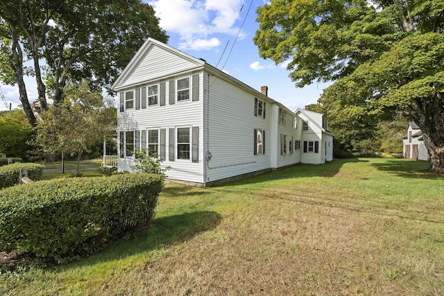 view of property exterior with a lawn and a chimney