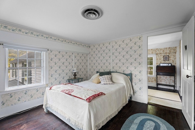 bedroom featuring baseboards, wood-type flooring, and wallpapered walls