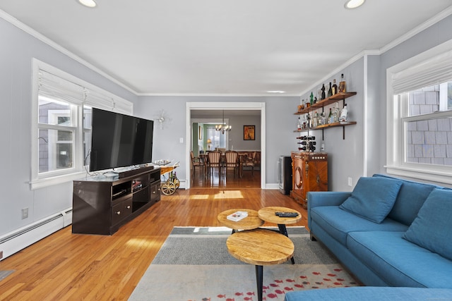 living area featuring a baseboard heating unit, ornamental molding, and light wood-style flooring