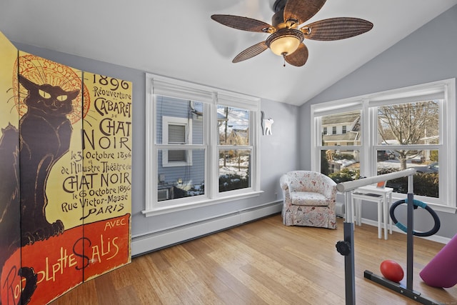 interior space featuring ceiling fan, vaulted ceiling, baseboard heating, and wood finished floors