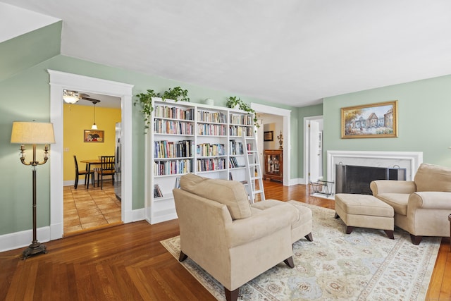 living area with parquet floors, a fireplace, and baseboards