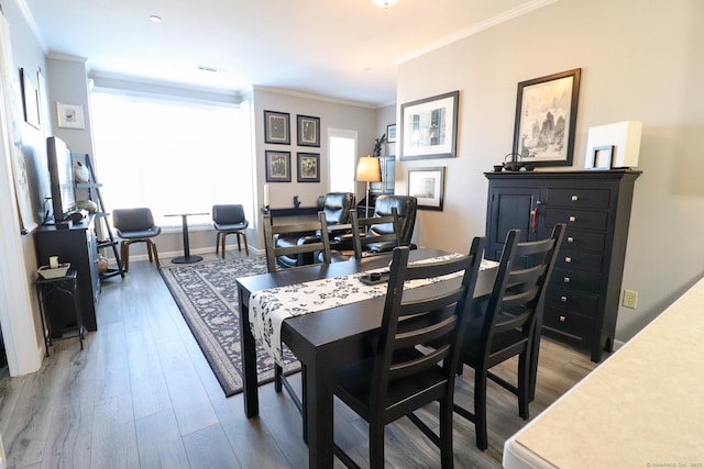 dining room with crown molding, baseboards, and wood finished floors