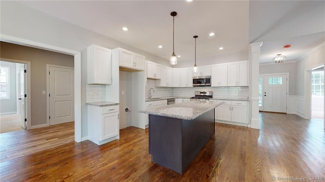 kitchen with dark wood-style floors, white cabinetry, stainless steel appliances, and a sink