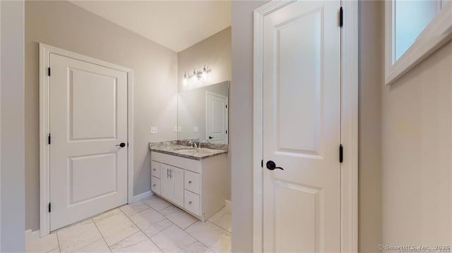 bathroom with marble finish floor and vanity