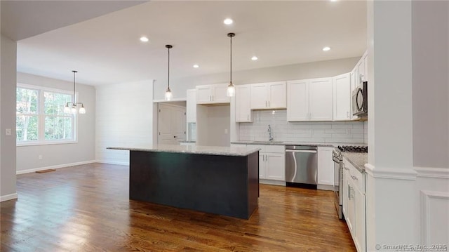 kitchen featuring dark wood finished floors, a kitchen island, appliances with stainless steel finishes, and a sink