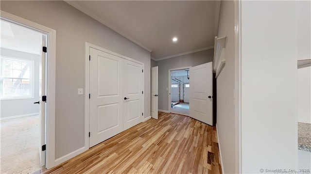 hallway with crown molding, recessed lighting, baseboards, and light wood finished floors