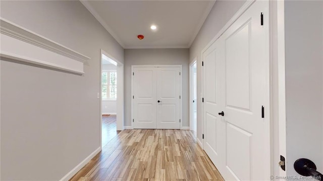 hall featuring crown molding, recessed lighting, baseboards, and light wood-type flooring