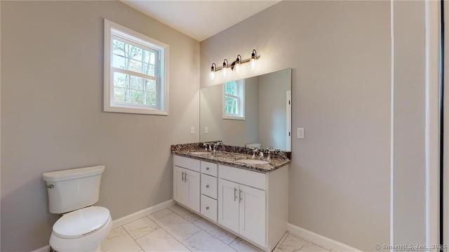 bathroom with marble finish floor, baseboards, and a sink