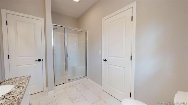 bathroom featuring vanity, toilet, marble finish floor, and a shower stall