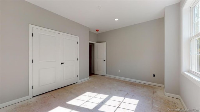 unfurnished bedroom featuring a closet and baseboards