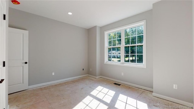 empty room featuring recessed lighting, visible vents, and baseboards