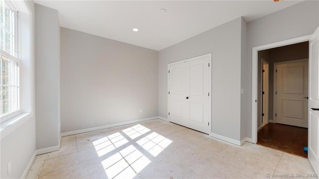 unfurnished bedroom featuring baseboards and a closet