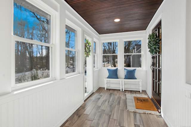 unfurnished sunroom featuring wood ceiling and plenty of natural light