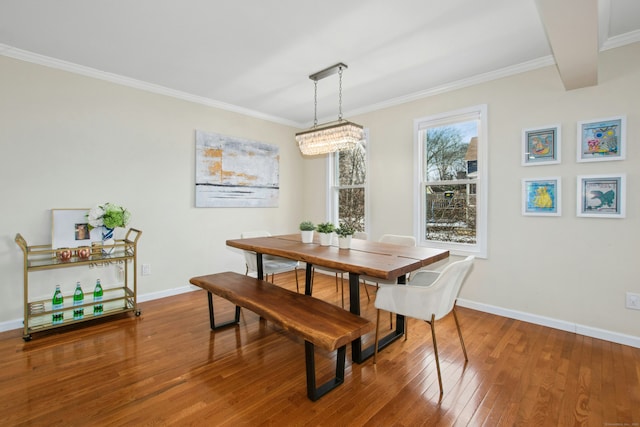 dining area featuring ornamental molding, hardwood / wood-style flooring, and baseboards