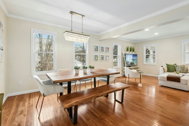 dining space featuring hardwood / wood-style flooring, baseboards, a chandelier, and ornamental molding