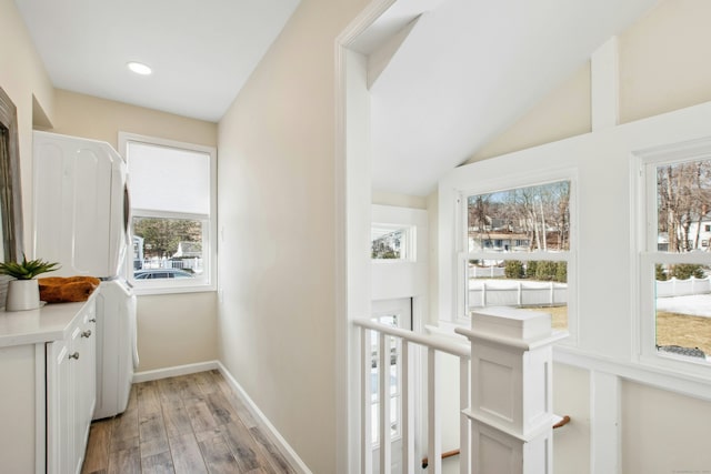 corridor featuring vaulted ceiling, recessed lighting, light wood-style flooring, and baseboards