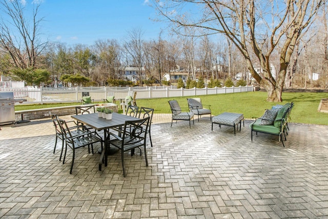 view of patio with outdoor dining area, grilling area, and a fenced backyard