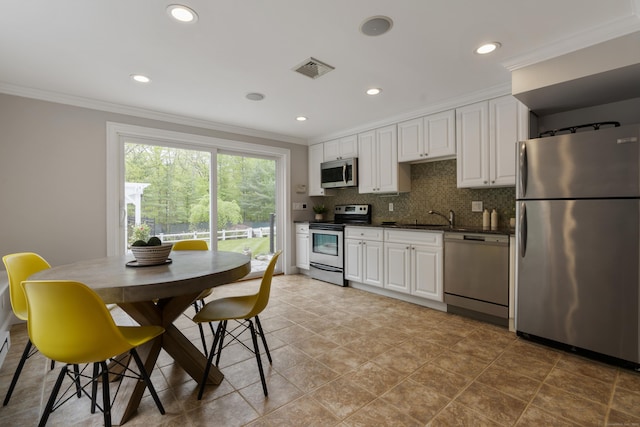 16 Whitehall Pl, Farmington, CT 06032 - kitchen with appliances with stainless steel finishes, ornamental molding, dark countertops, a sink, and white cabinetry