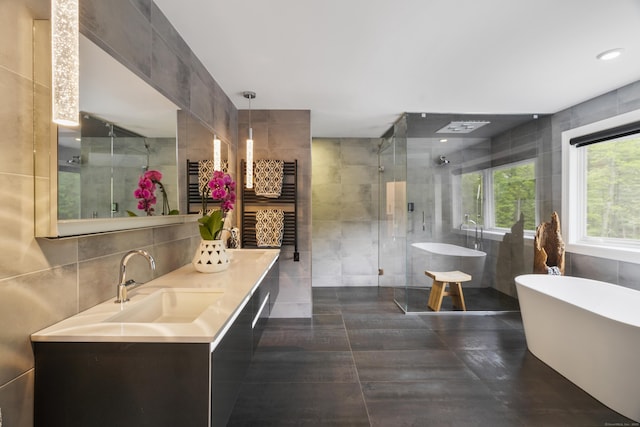 16 Whitehall Pl, Farmington, CT 06032 - bathroom with tile walls, a towel warming rack, a soaking tub, a stall shower, and double vanity