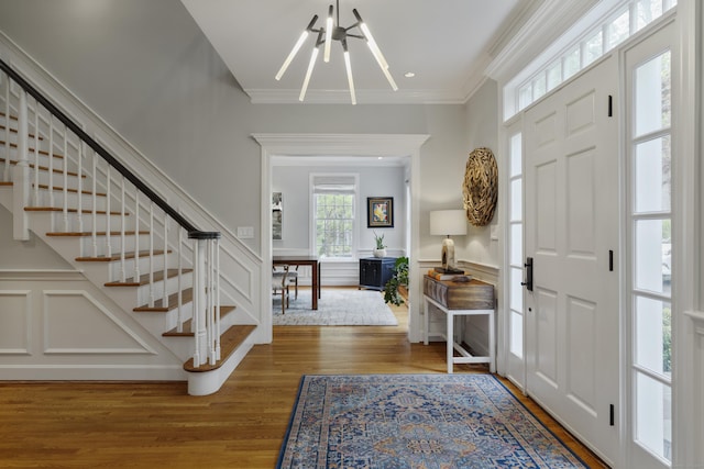 16 Whitehall Pl, Farmington, CT 06032 - foyer entrance with a chandelier, crown molding, stairs, wood finished floors, and wainscoting