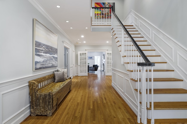 16 Whitehall Pl, Farmington, CT 06032 - entryway with ornamental molding, a decorative wall, stairs, french doors, and wood finished floors